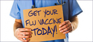 Nurse holding sign that says "Get your flu vaccine today"