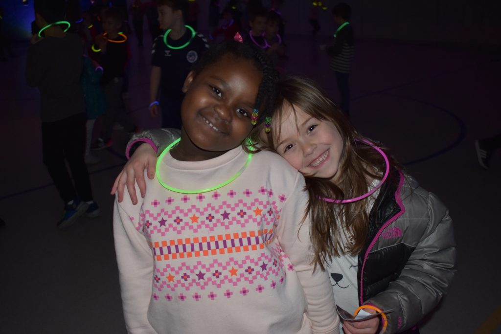 Two girls hugging at the glow dance party