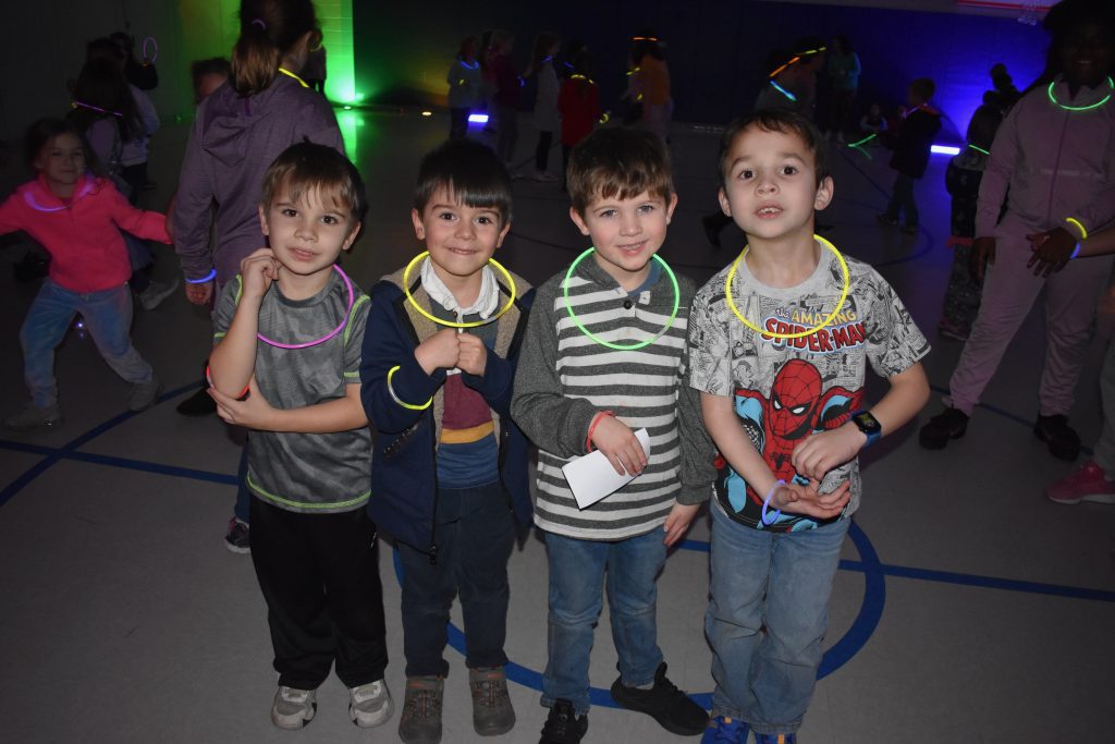 four students smiling at the glow dance party