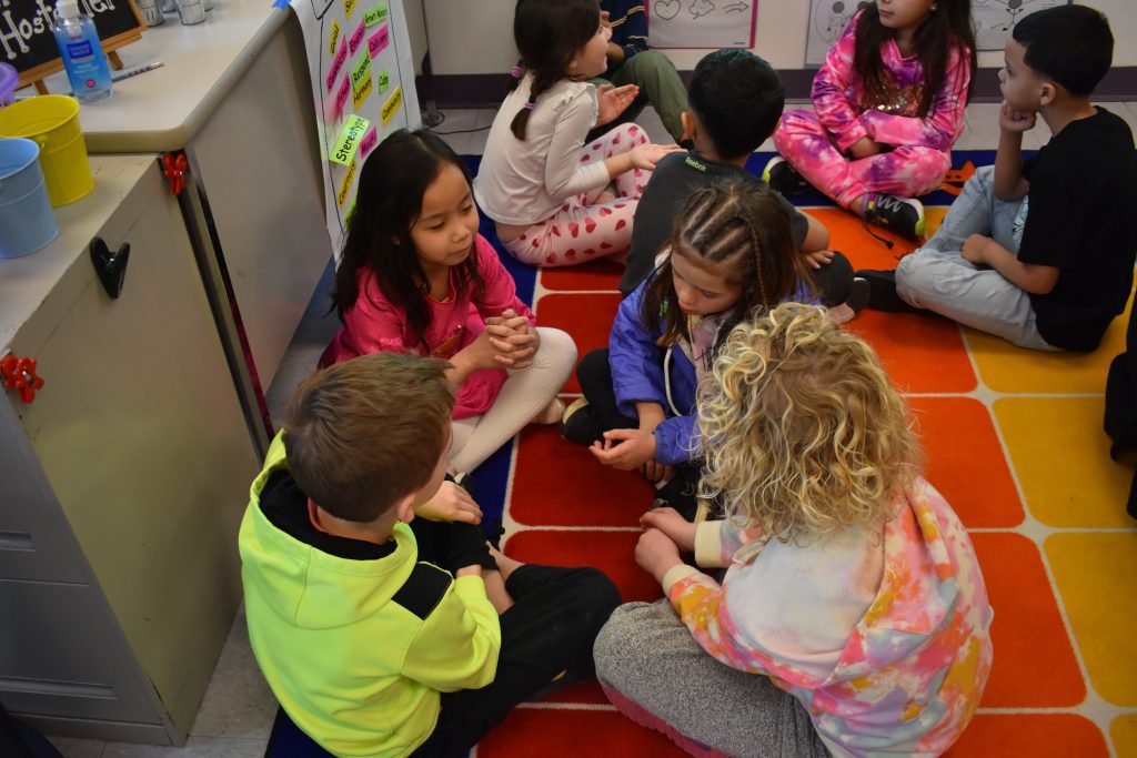 students sitting on the floor talk at the Wescosville Elementary morning “meet-ups”