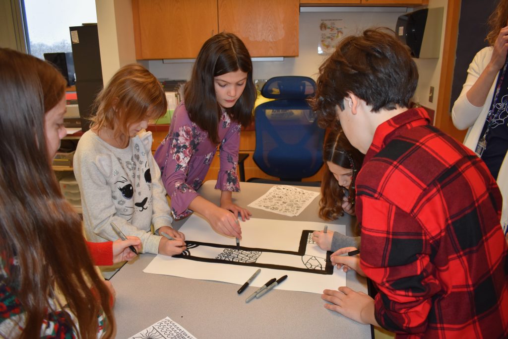 Student gathered together drawing on a table