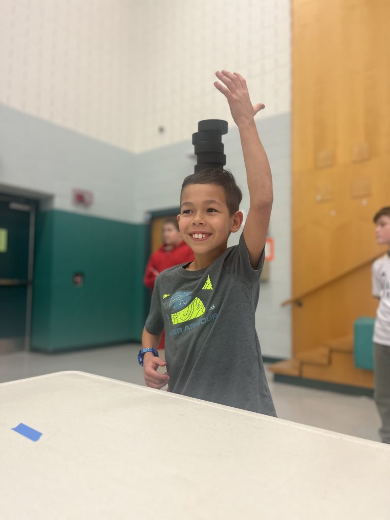 Jefferson student balancing hockey bucks at the inaugural Minute to Win it games 