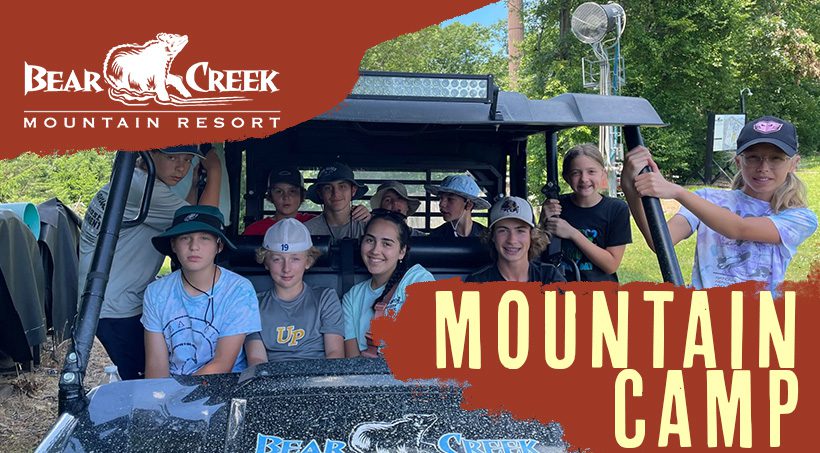 A group of smiling teenagers riding in a UTV during the Bear Creek Mountain Camp program.